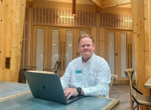 IT volunteer Gary sits at a table in front of his lap top