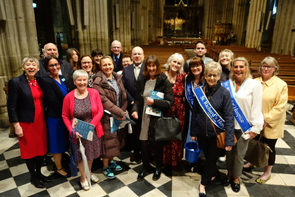 A large group of people standing together for a photo inside Worcester Cathedral.