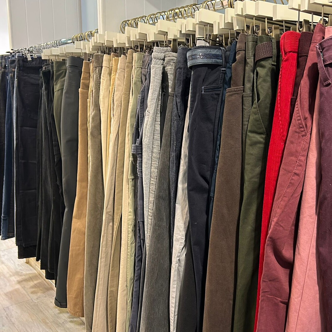 Men's trousers on a rail in the hospice's pop-up shop.