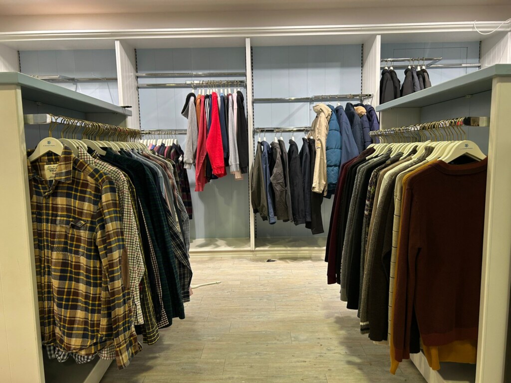 Menswear on rails and racks of clothing inside the pop-up shop.