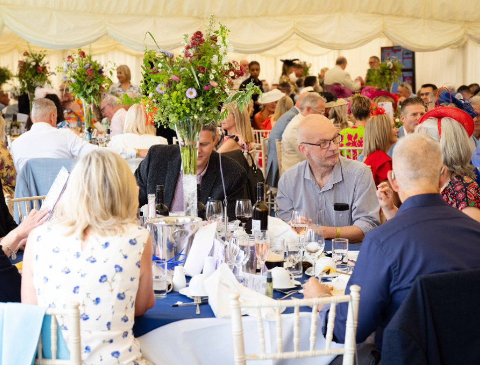 A marquee full of ladies day attendees seated for food and drinks.